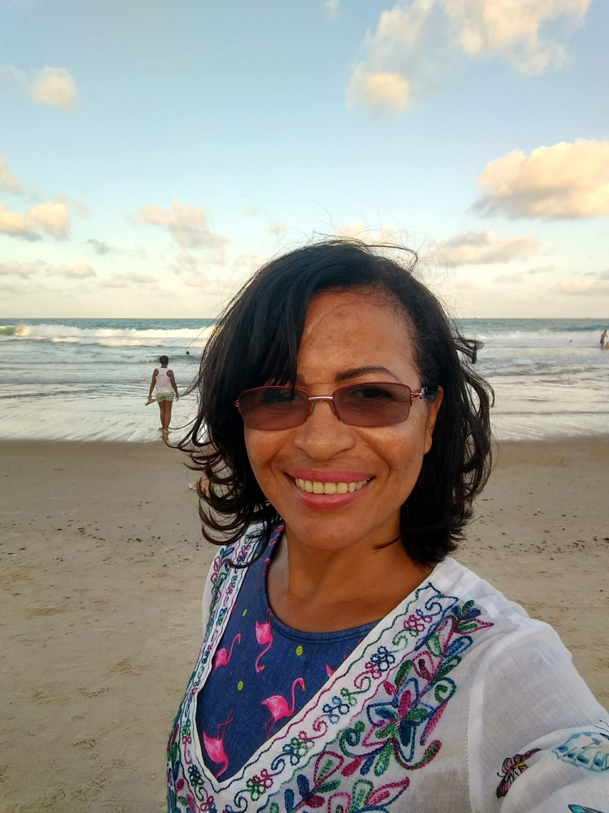 Rejane Arruda na praia, sorrindo